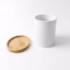 Petit pot cylindrique blanc en céramique posé debout à côté de sa soucoupe en bambou, prêt à être personnalisé avec une photo ou un texte.